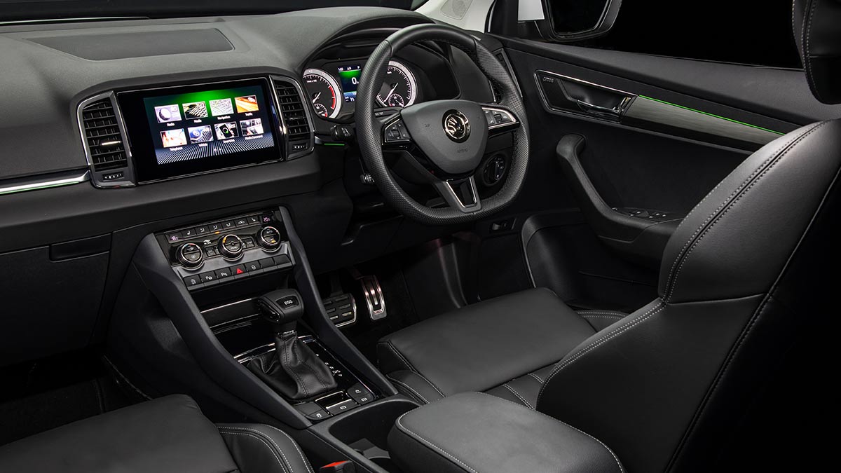 Dark grey interior of the Skoda Karoq 2019 showing the driver's seat, steering wheel and centre console