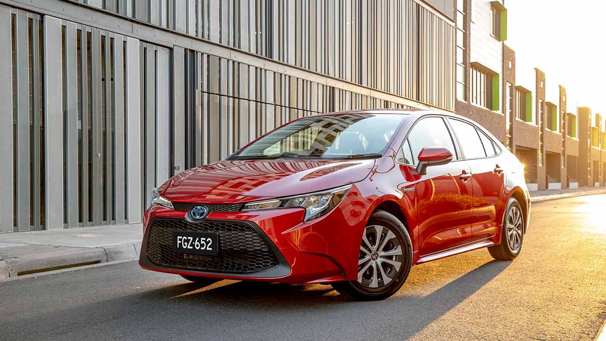 A red Toyota Corolla with the sun in the background