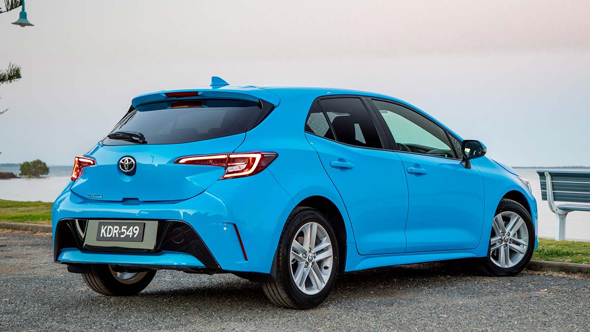 Rear side view of a blue Toyota Corolla 2018 car parked next to the sea