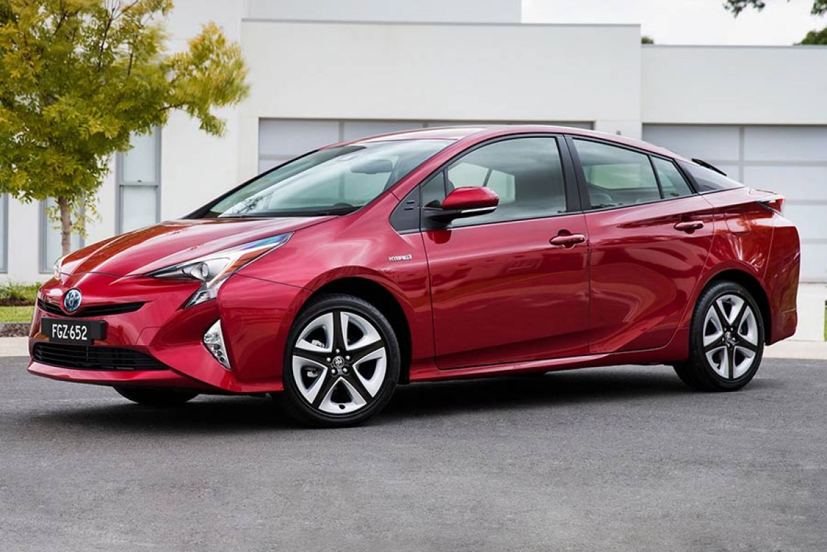 Front side view of a red Toyota Prius car parked on a residential street