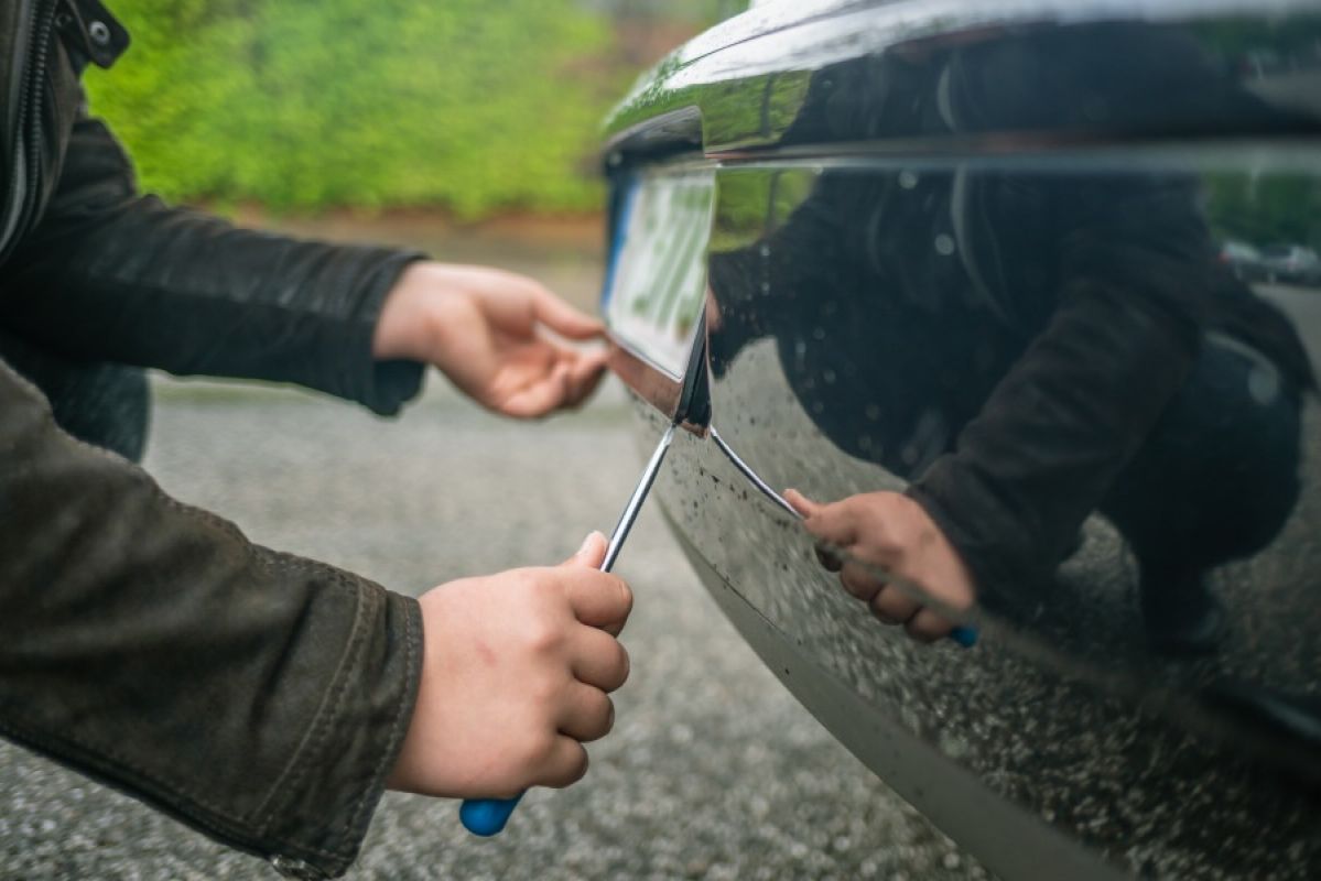 thief removing car number plates