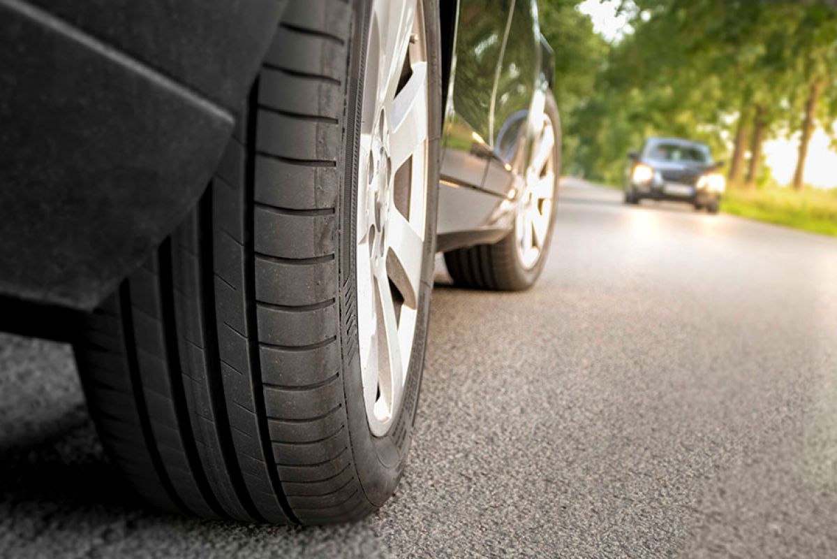 Car driving on road with close up of tyres