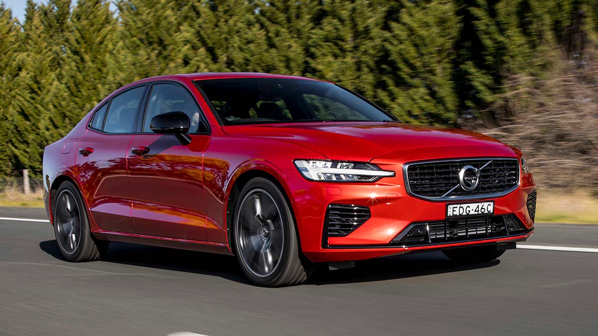 Front side view of a red Volvo S60 T8 R-Design 2020 car driving on a road