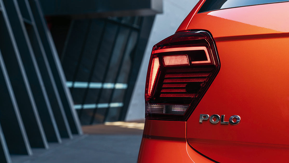Close up of the tail light and Polo badge of a metallic orange-red Volkswagen Polo 2018 car