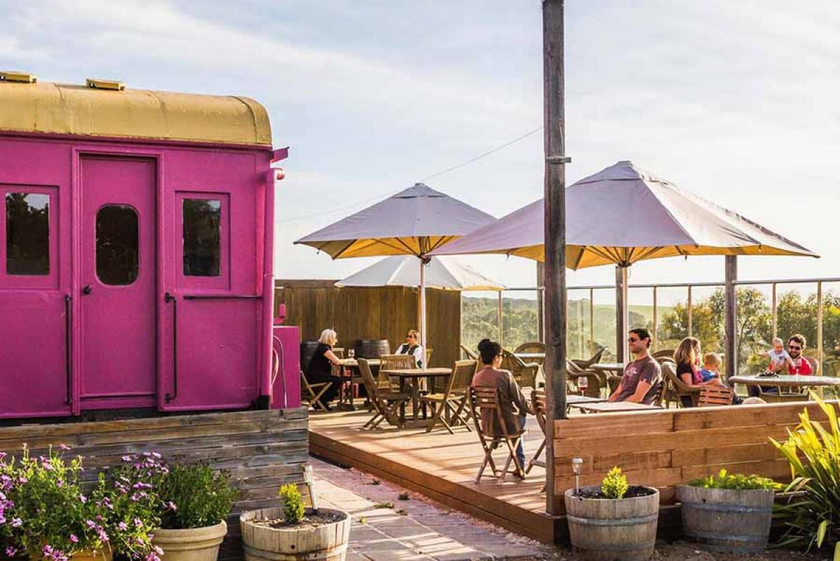 Umbrellas on deck at winery with pink door