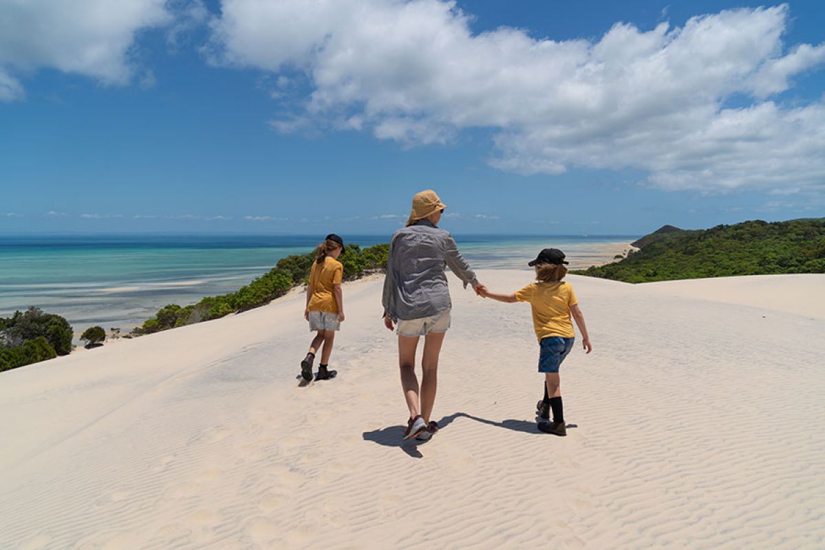 Young family enjoying a walk along a beach in Brisbane