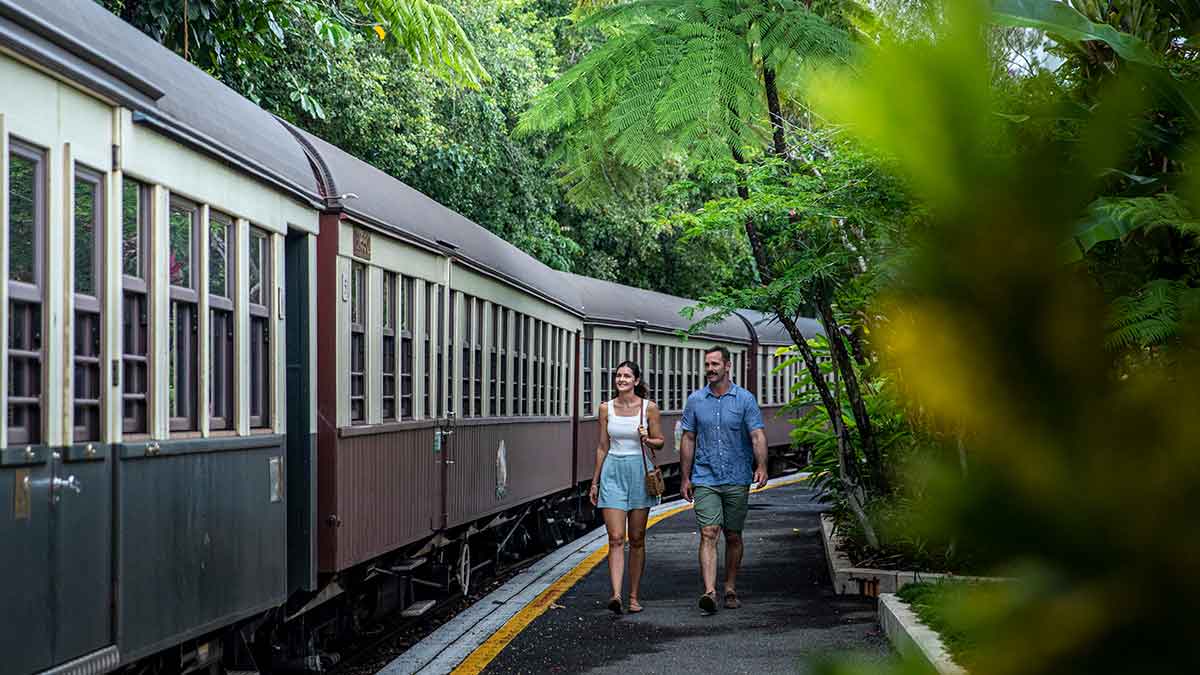 Two people walking beside a train