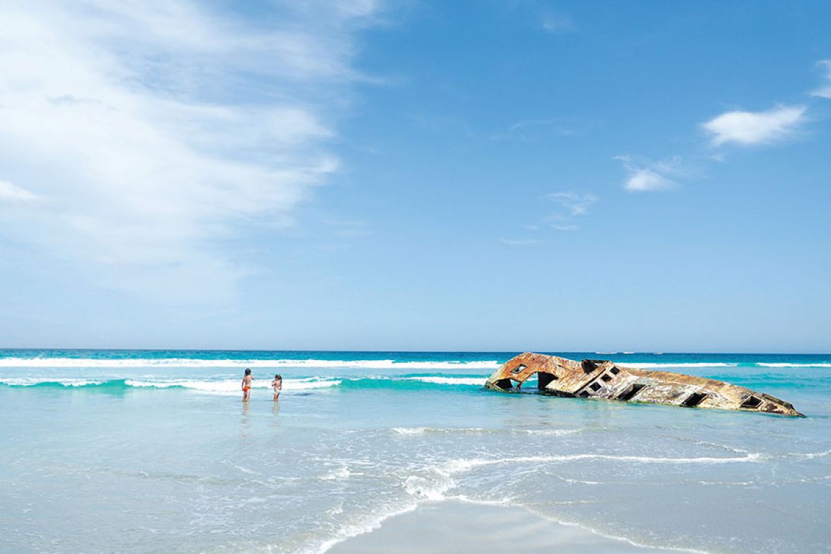 two kids playing on open stretch of beach