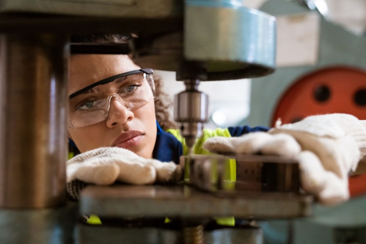 A woman wearing safety equipment while using machinery