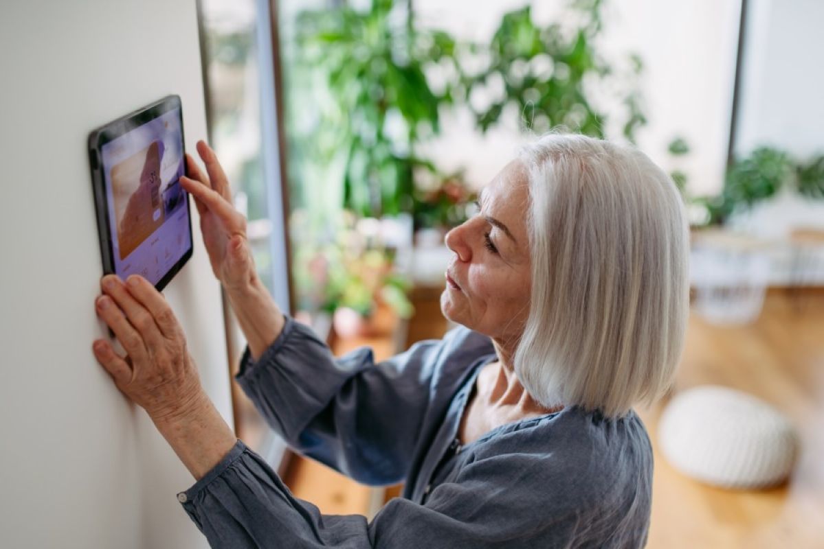 senior woman adjusting her home connectivity screen
