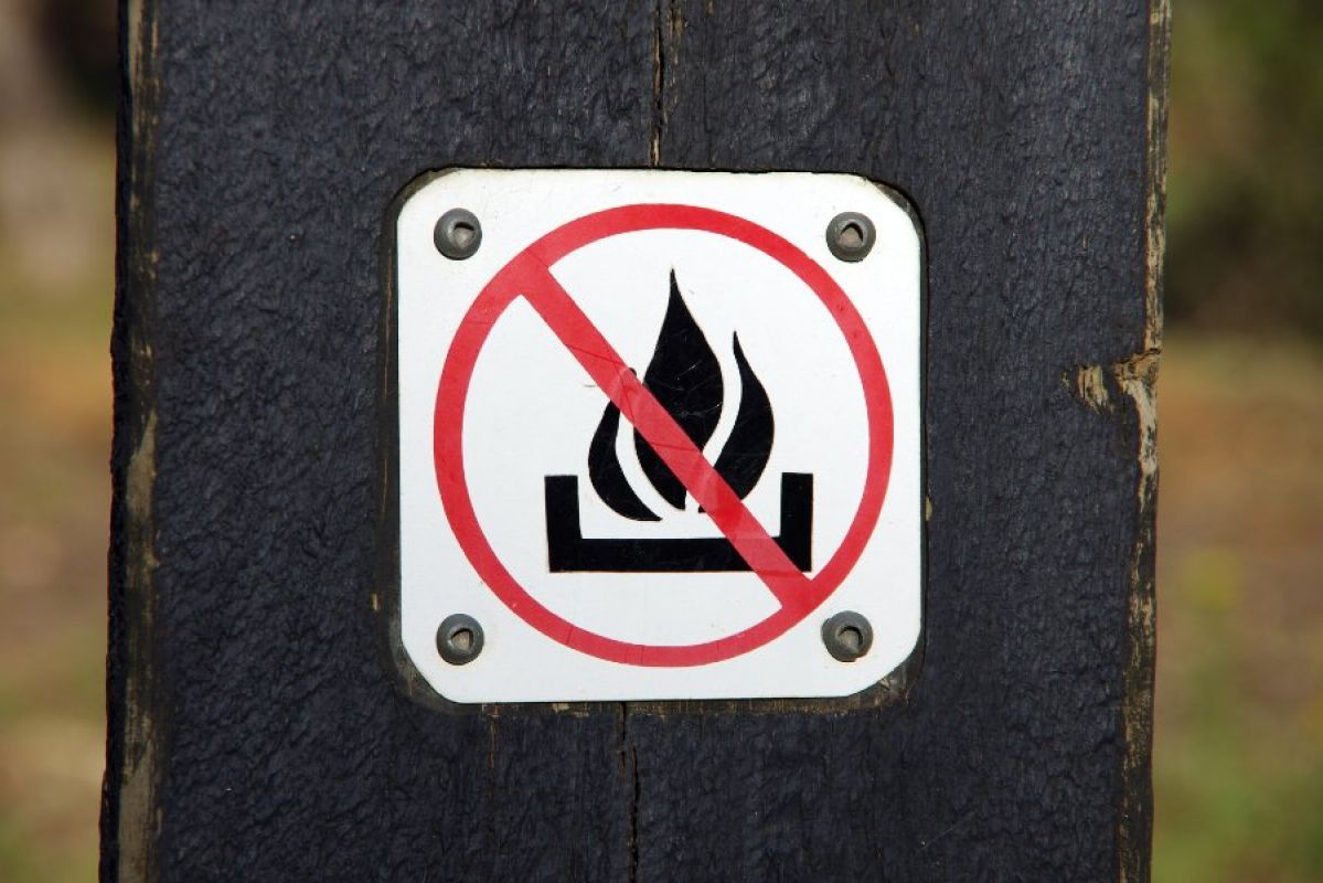 sign on post of a fire with a cancel sign