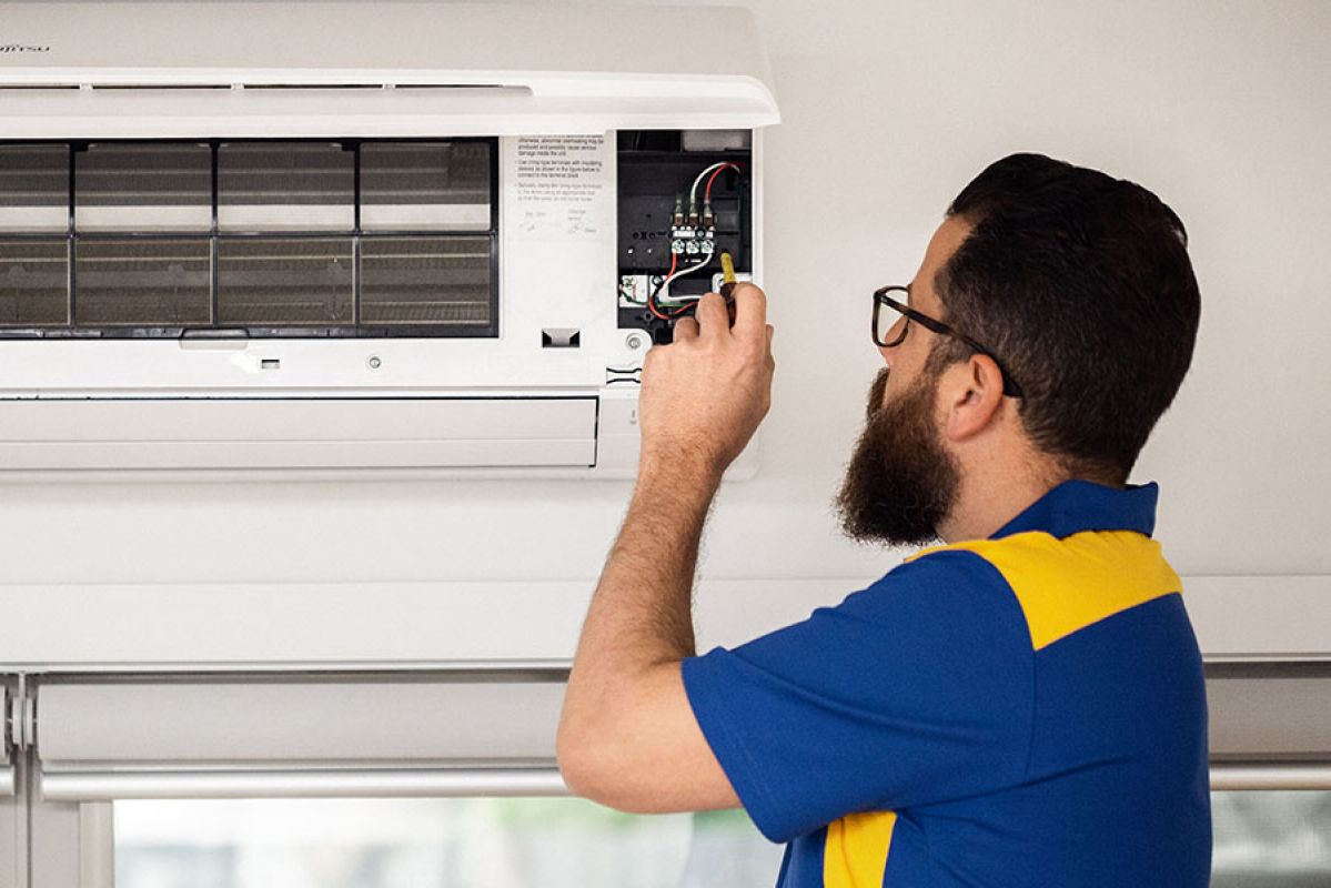 RACV tradesman fixing air conditioning unit