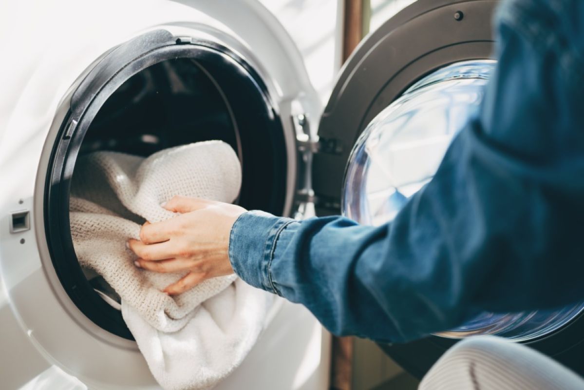 person loading clothes dryer
