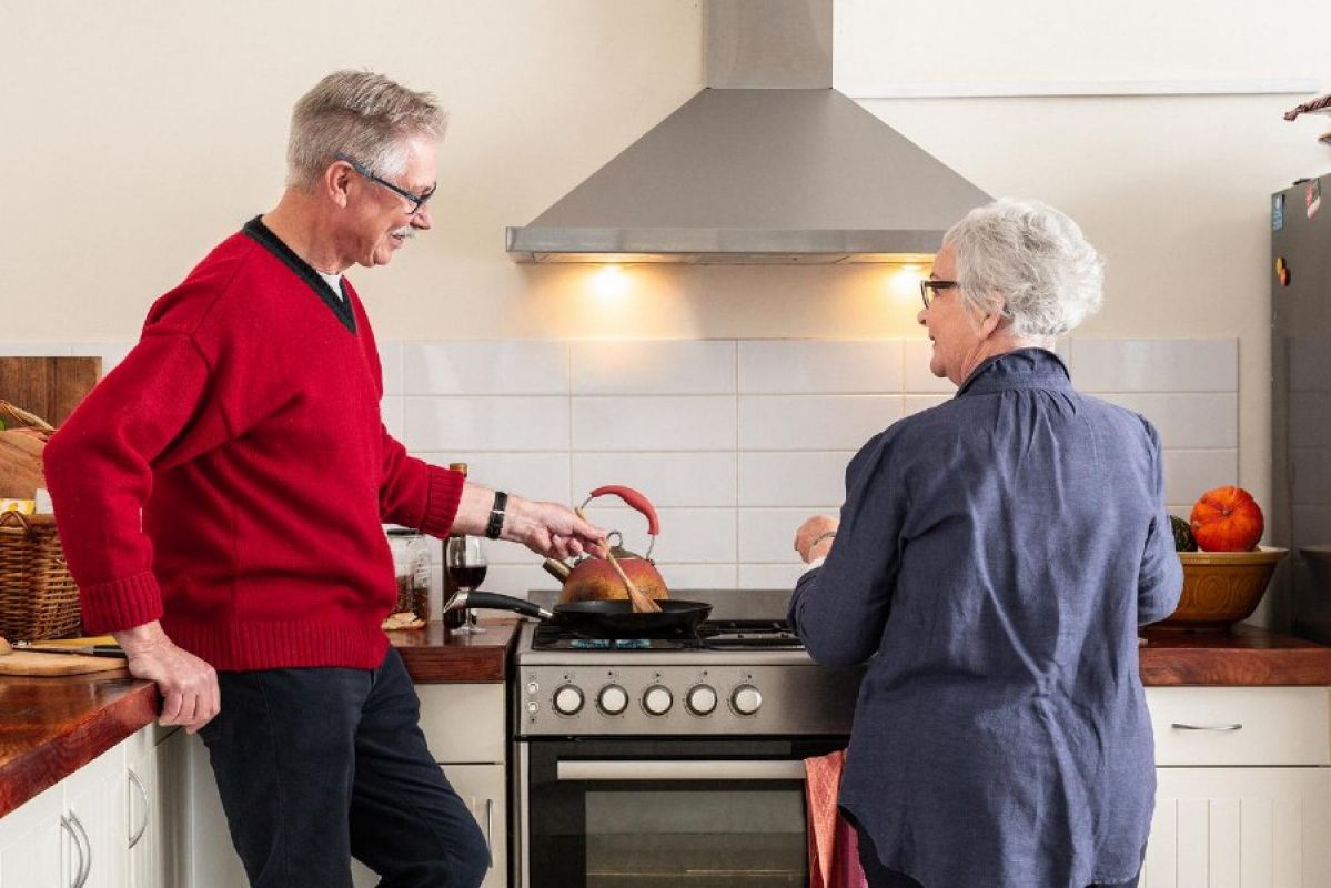 An elderly couple cooking in a kitchen