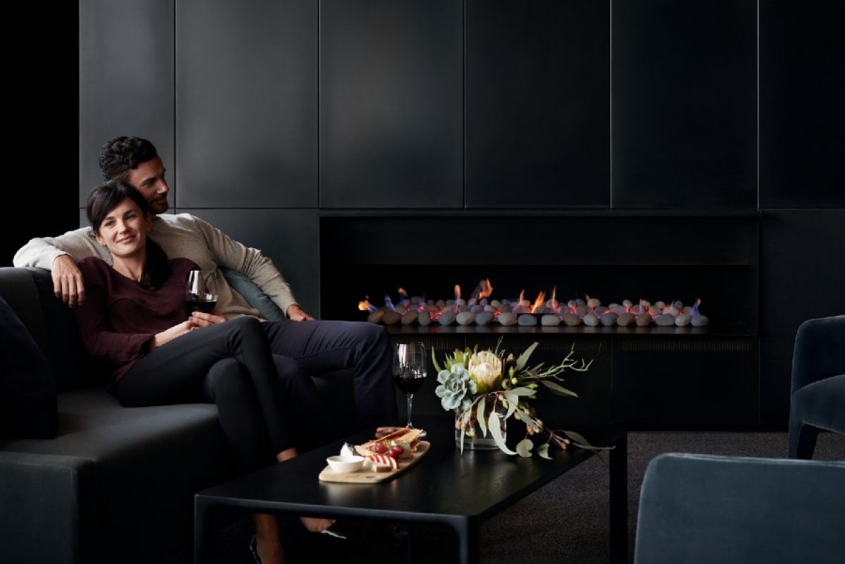 A couple relaxing in a modern lounge room next to a stylish gas fireplace