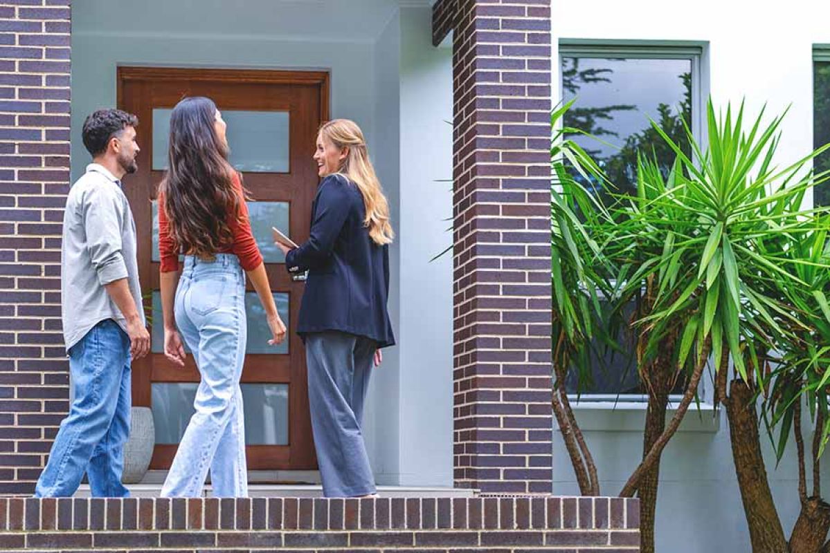couple at front door of new home with agent