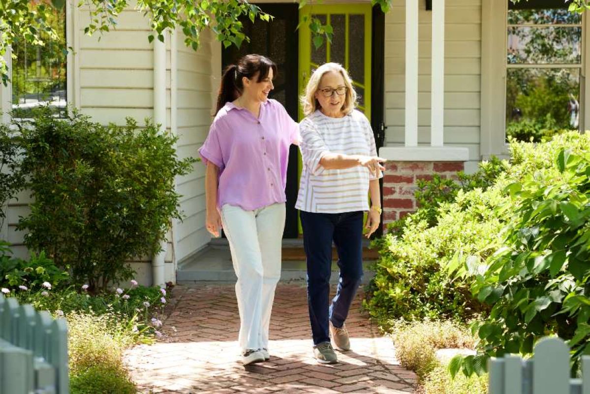 young and middle-aged woman walking out of a house together