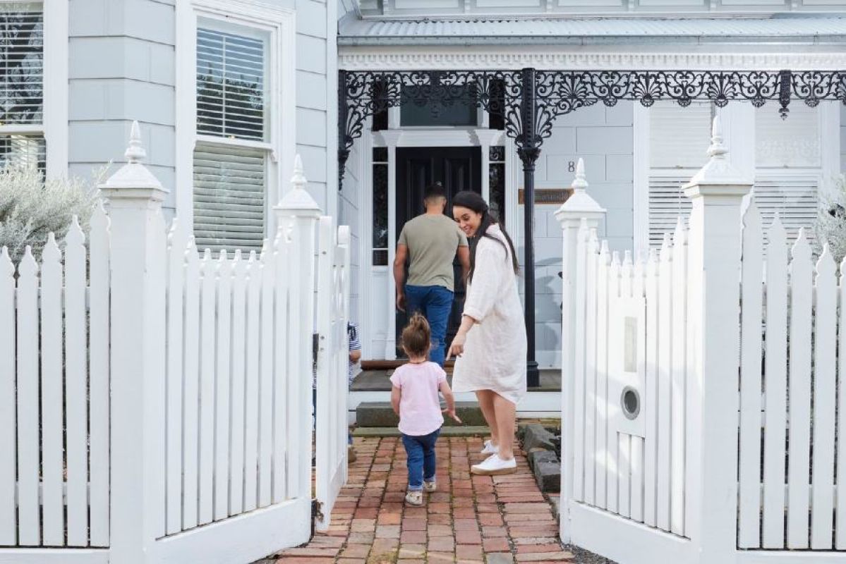 A family with a young child entering a house