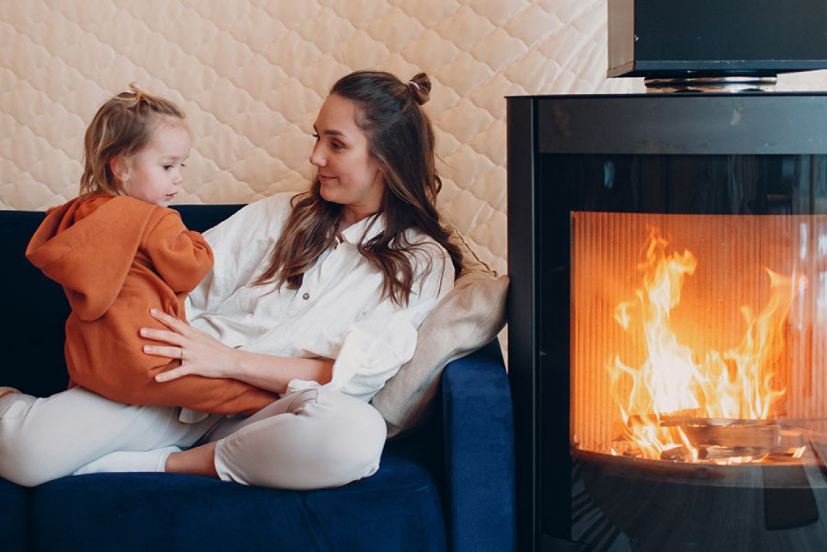 Mother and daughter on couch next to fireplace