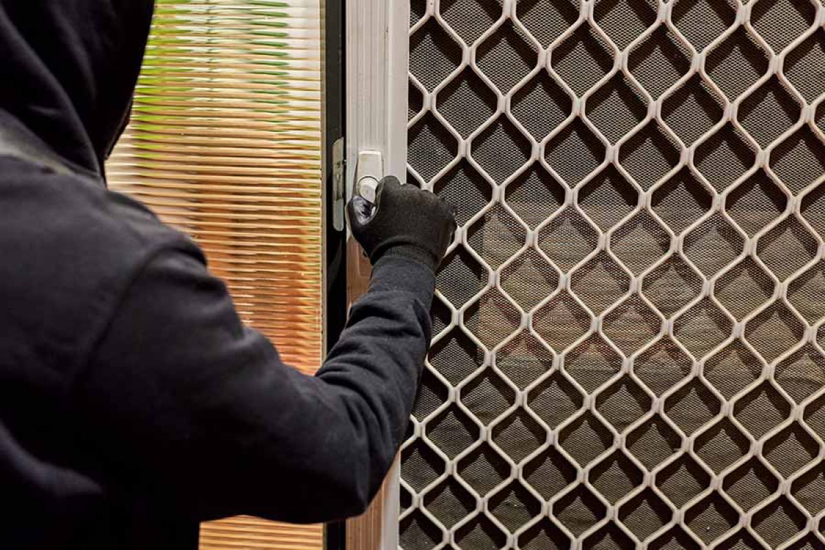 burglar opening security door of home