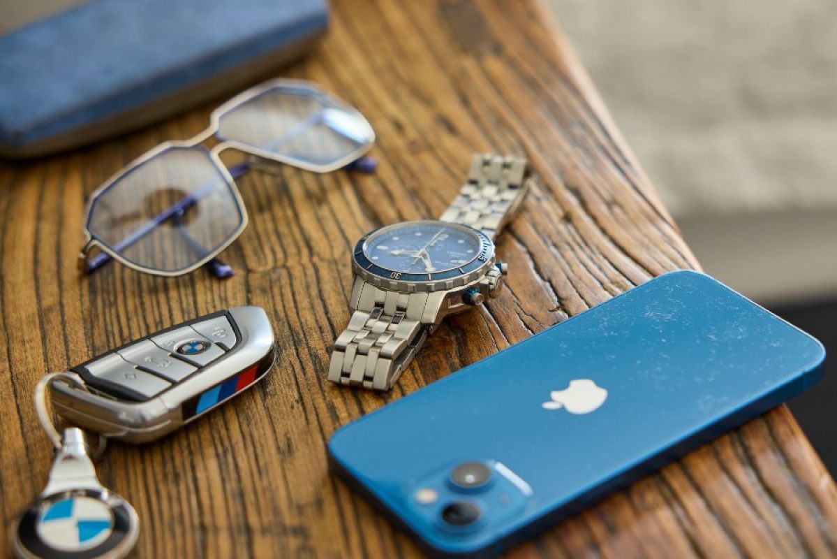glasses, car keys, watch and smartphone on bench