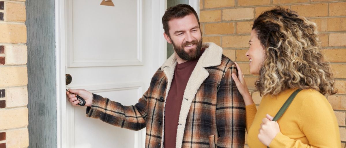 man and woman unlocking front door