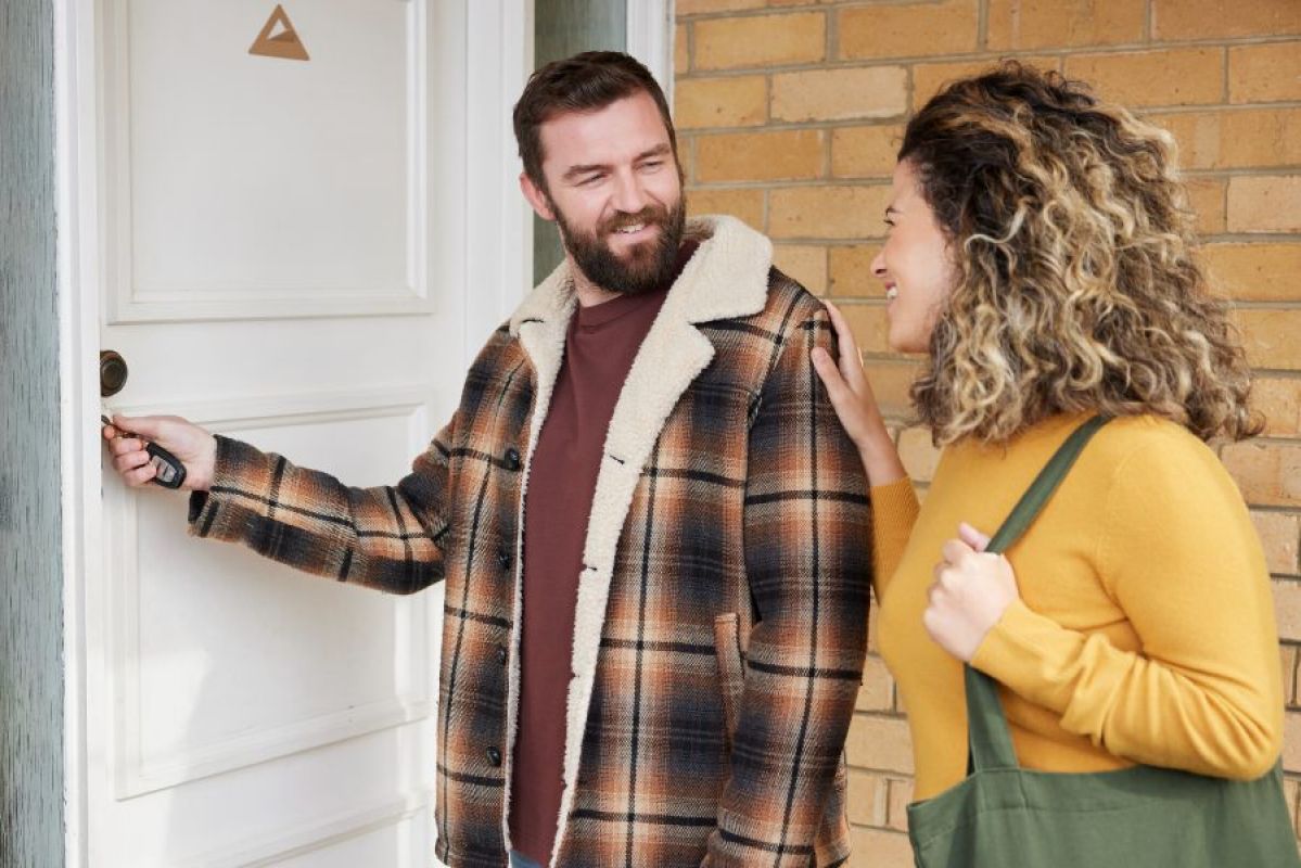 man and woman unlocking front door