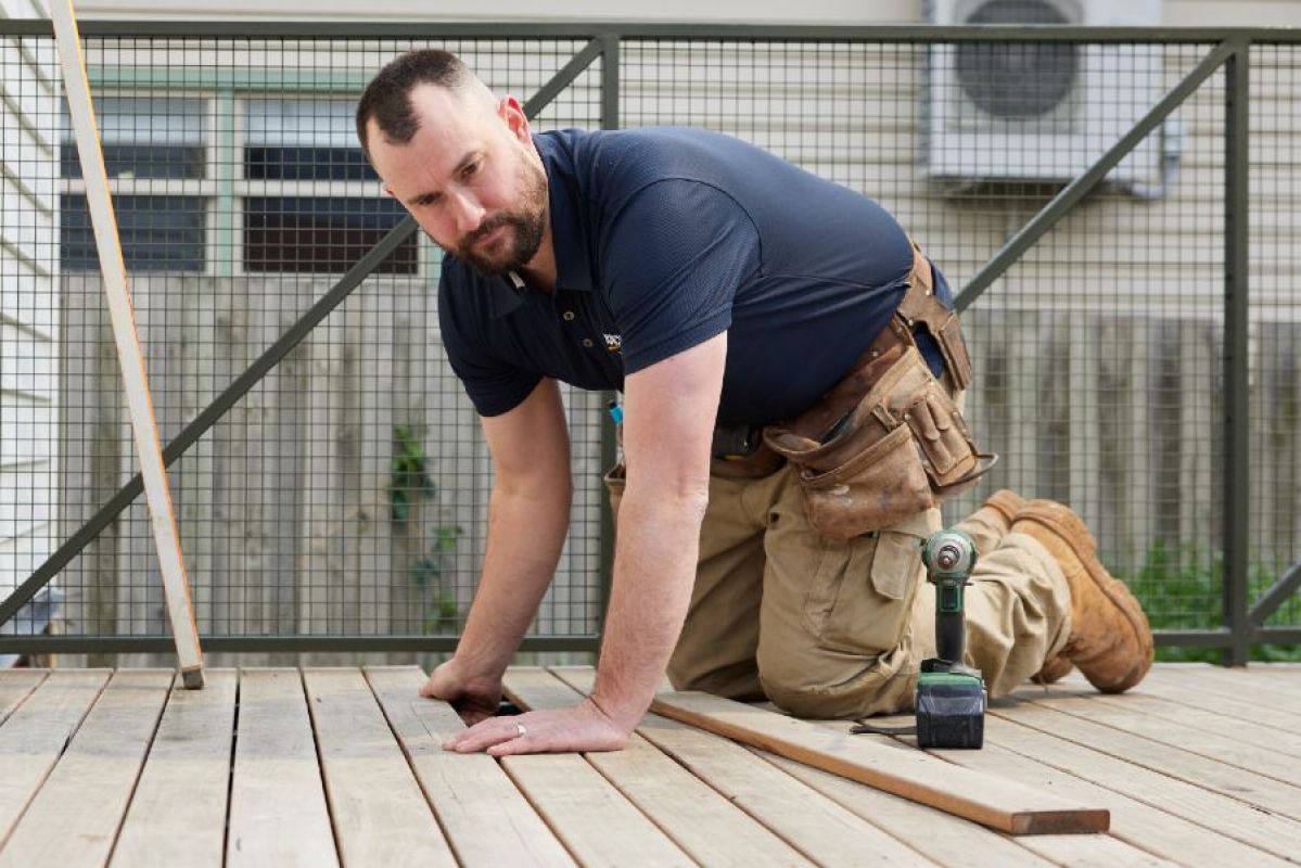male tradie performing deck repairs