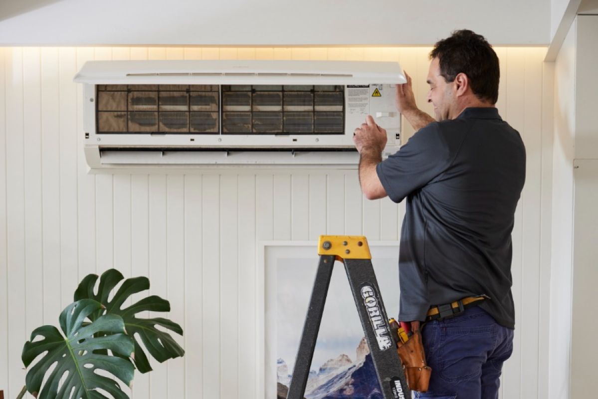RACV tradesman fixing air conditioning unit