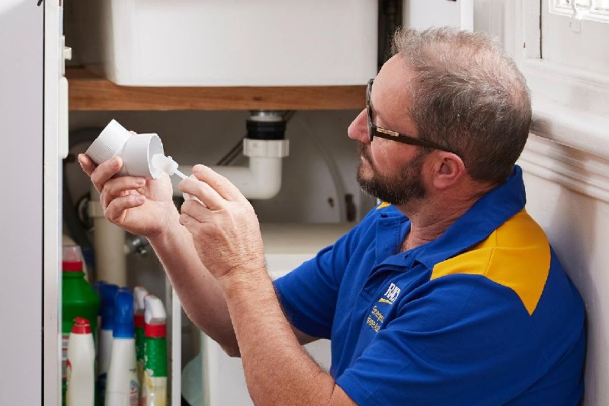 RACV tradesperson repairing a sink pipe