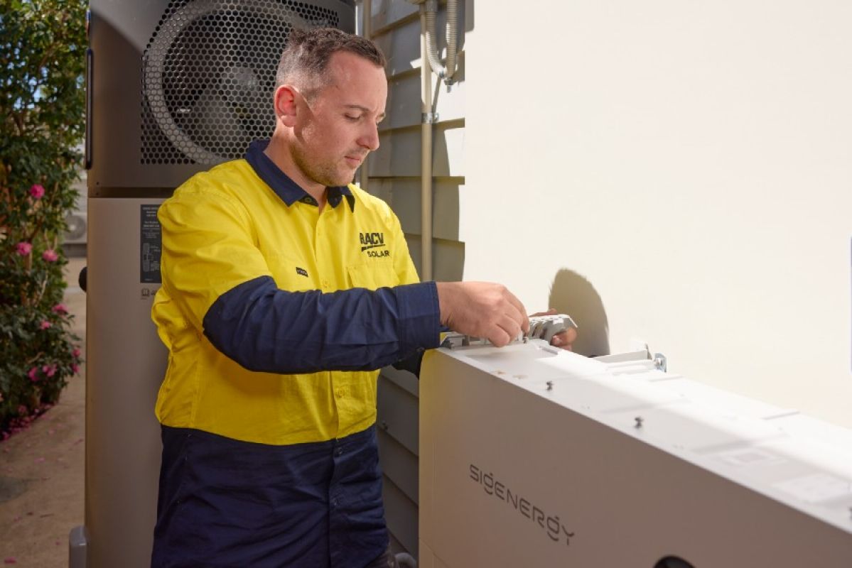 An RACV solar technician installing a solar battery