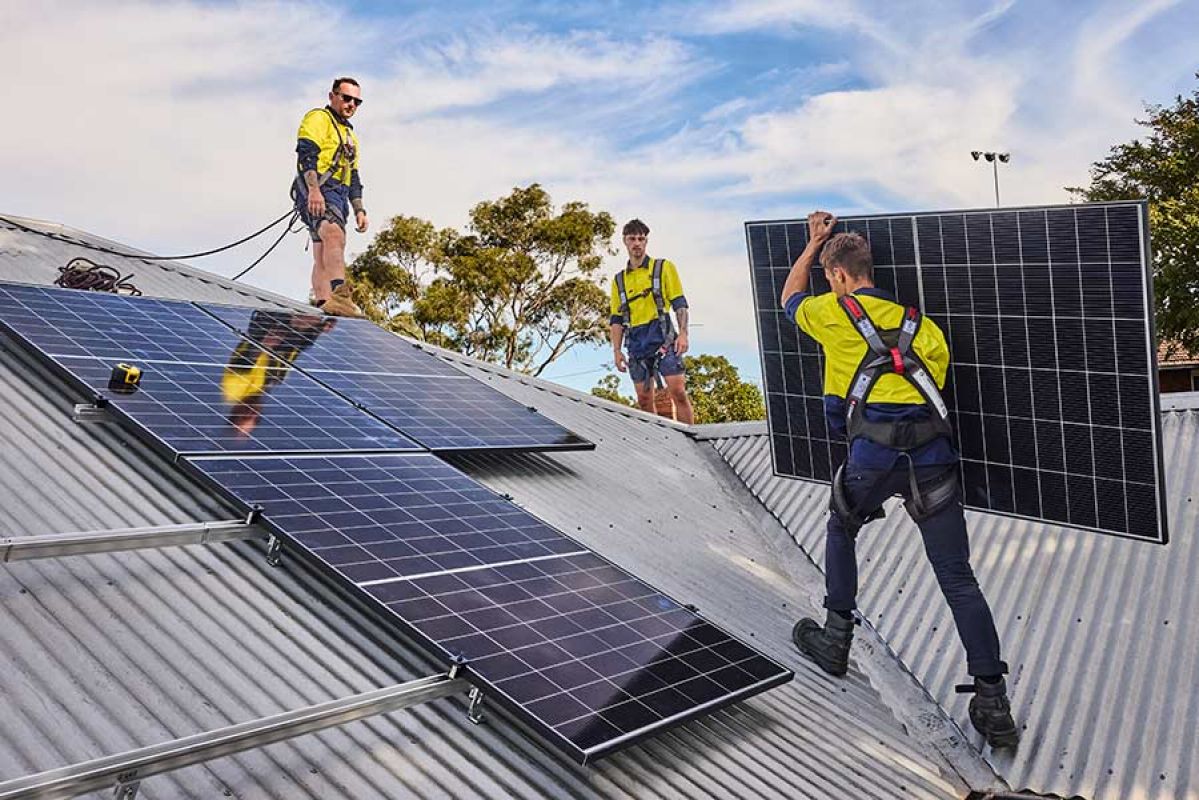 Technicians installing solar panels on a colourbond roof