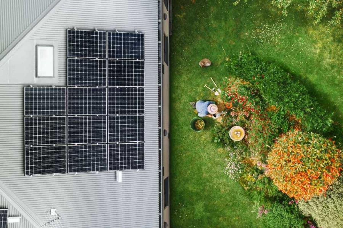 aerial shot of woman gardening and rooftop solar panels