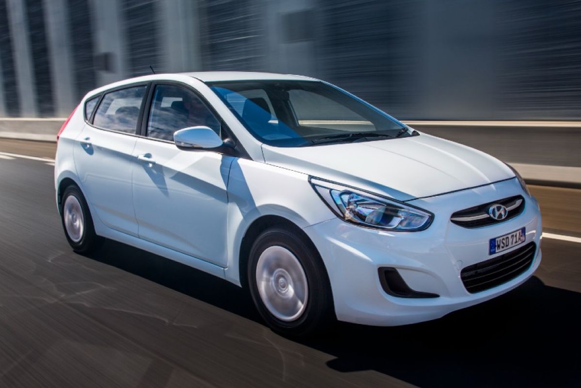 A white Hyundai Accent 2016 driving on a road