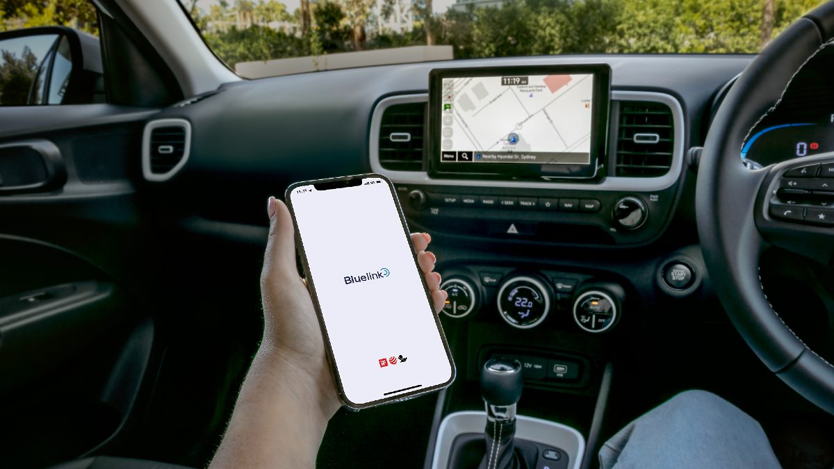 interior Hyundai Venue Elite, person using Bluelink on phone and car