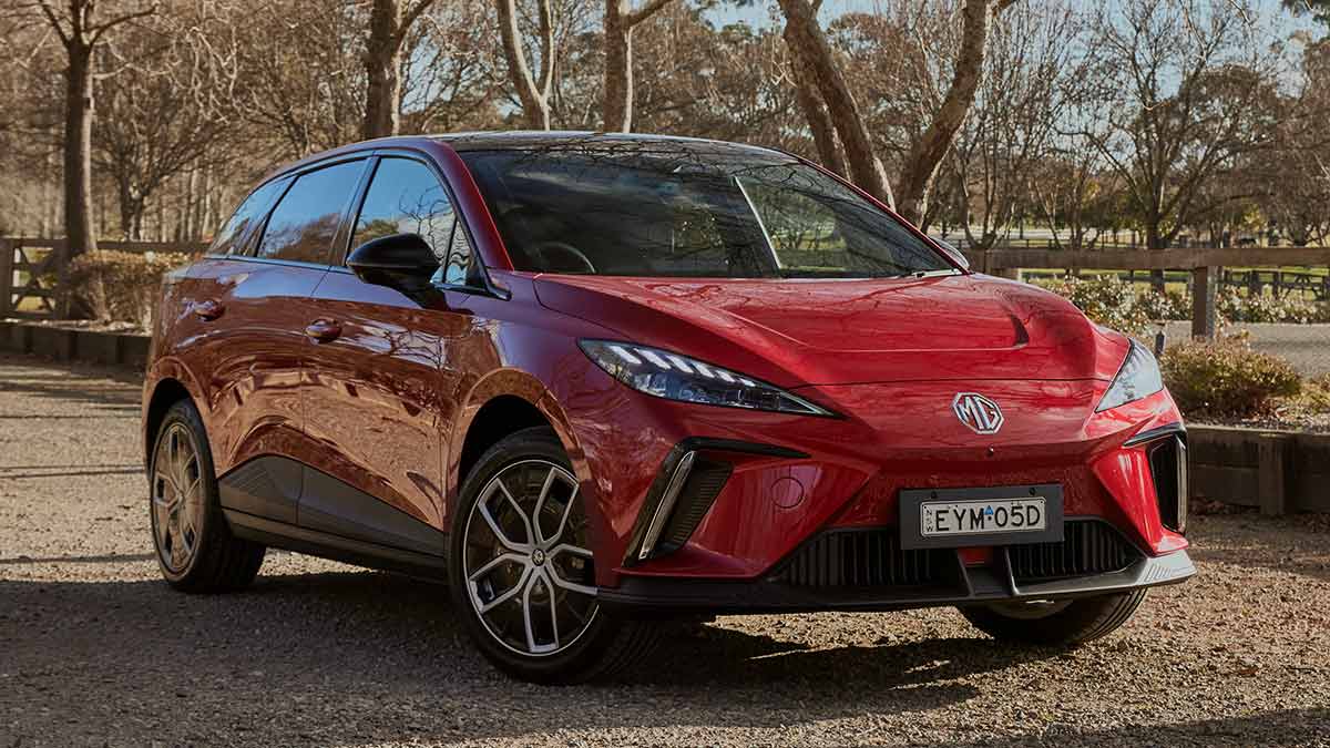 Red MG4 electric car on gravel driveway in country