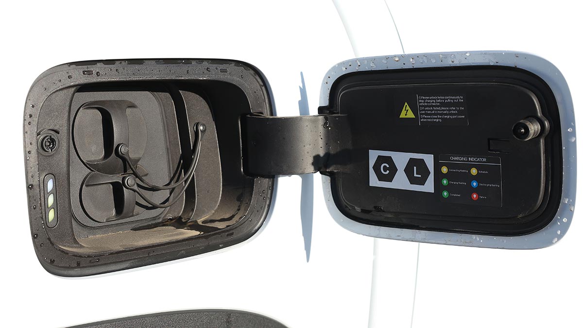 Battery charging socket behind flap of white BYD Shark 6 Premium ute