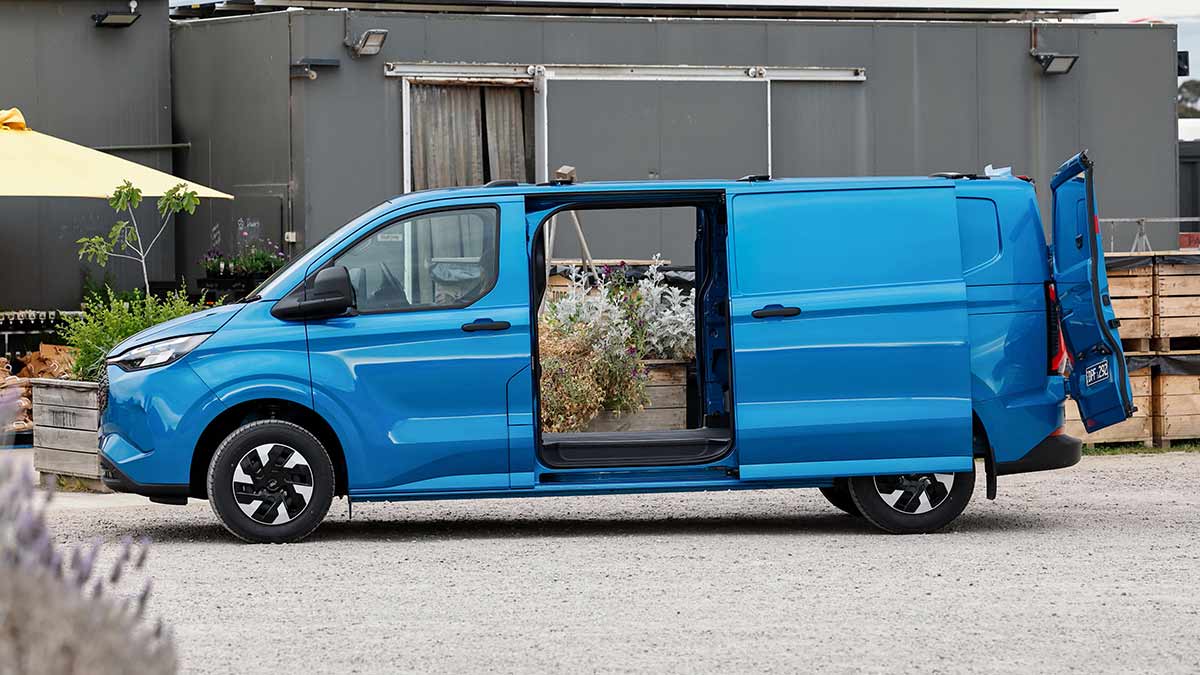 Blue E-Transit Custom van at market garden with dual sliding doors open.