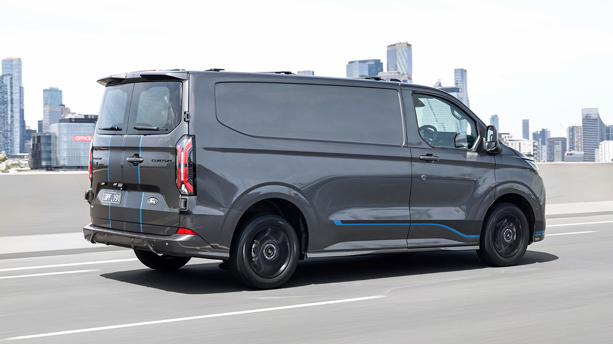 Grey Ford Transit Custom van on Bolte Bridge with Melbourne CBD skyline behind.