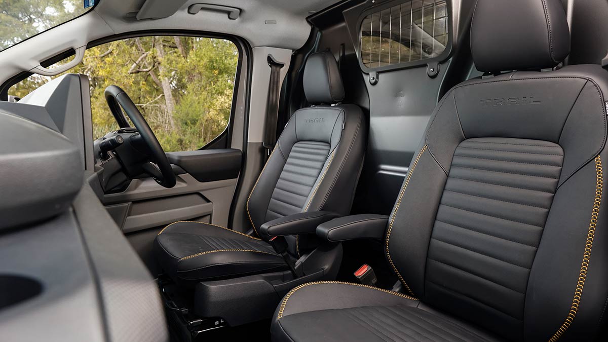 Ford Transit Custom Trail van cabin with two individual seats highlighting yellow stitching and Trail name embossed on seatbacks.
