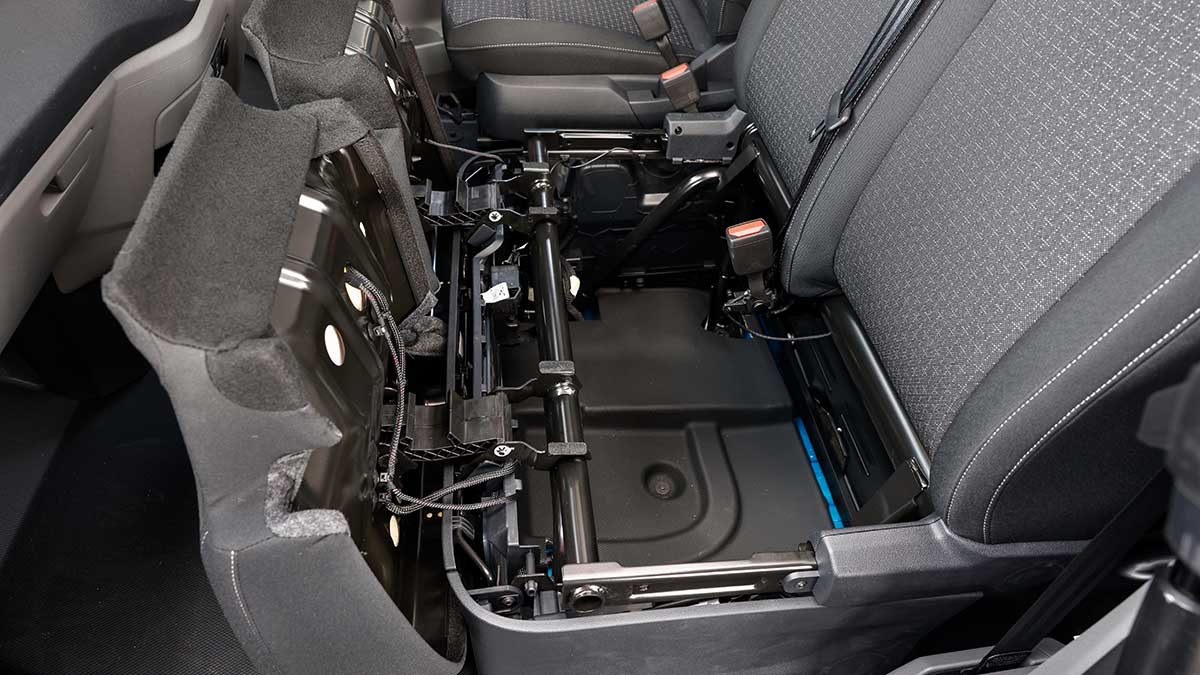 Under-floor storage areas below passenger seats in Ford Transit Custom van.