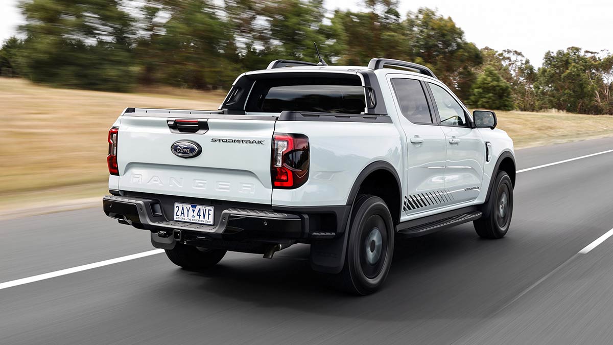 Rear view of white Ford Ranger PHEV Stormtrak ute on freeway in regional Australia