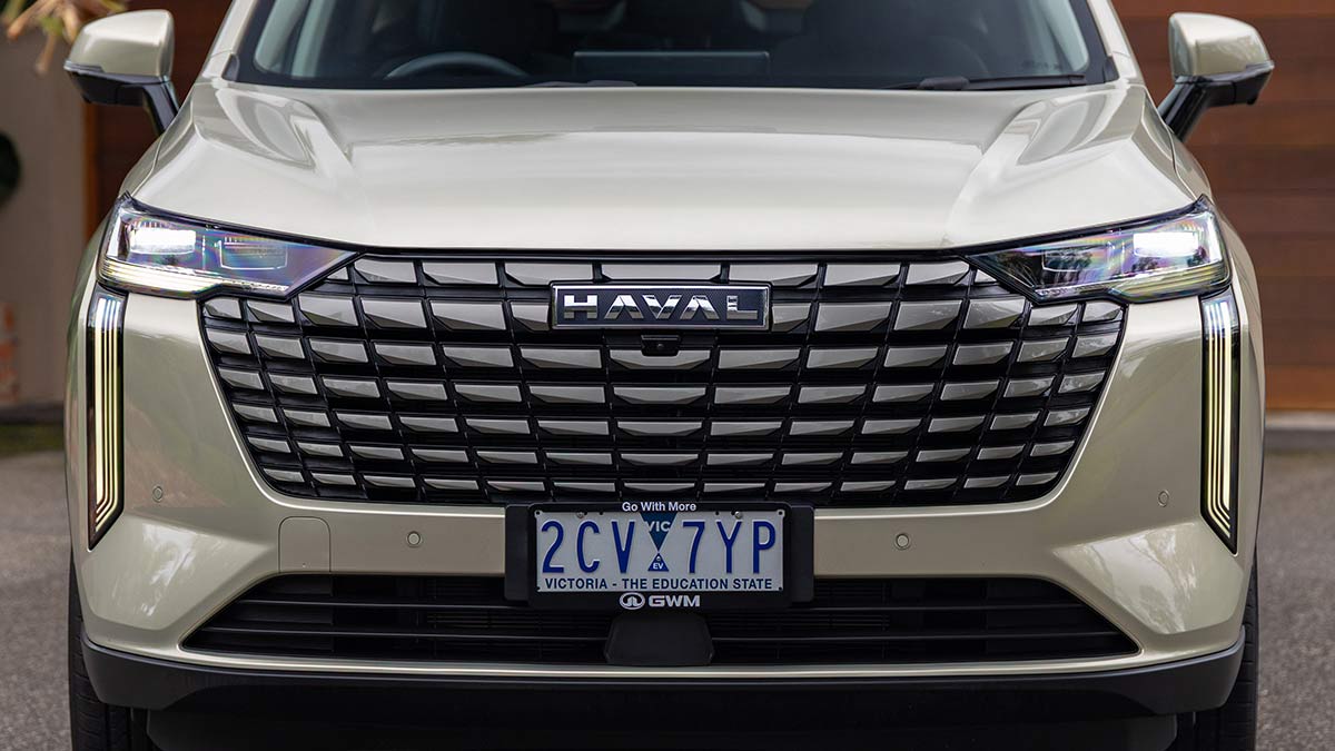Close-up of new cascading grille and vertical daytime running lights on pearl-coloured GWM Haval H6 Ultra PHEV.