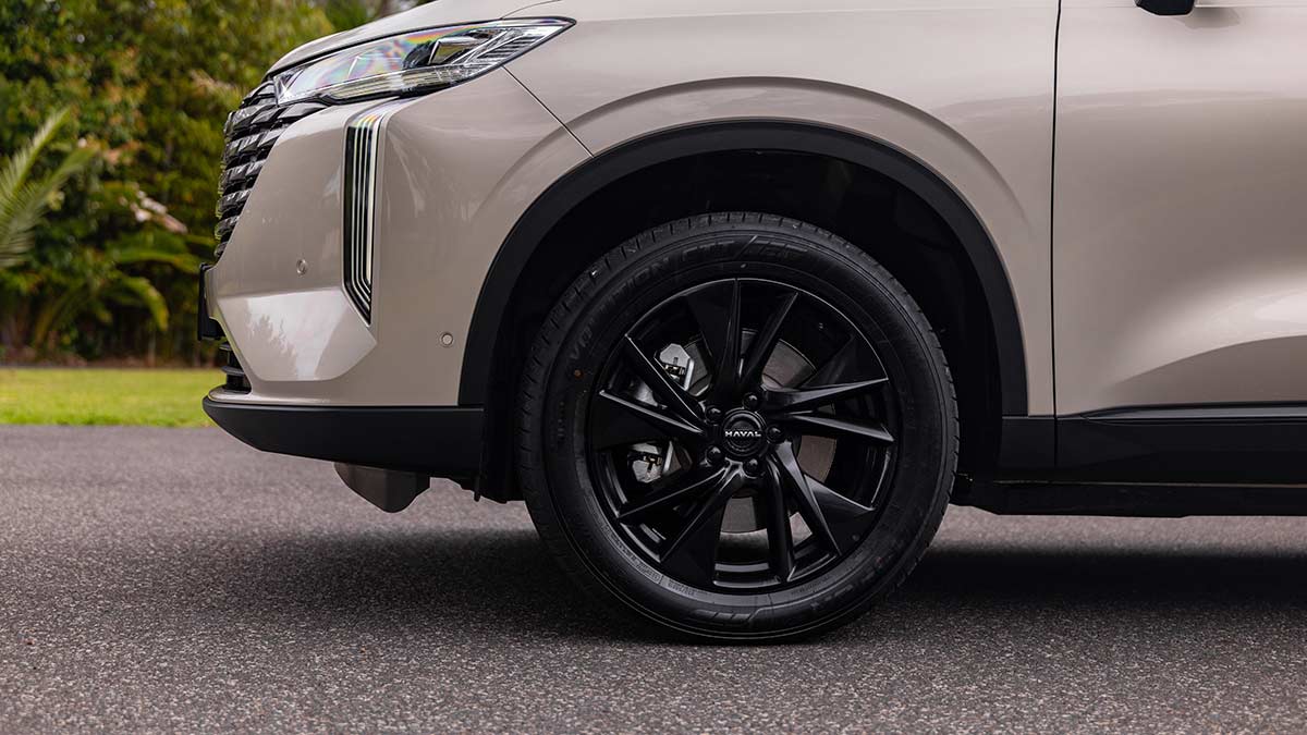 Close-up of new 19-inch black alloy wheels on pearl-coloured GWM Haval H6 plug-in hybrid SUV.