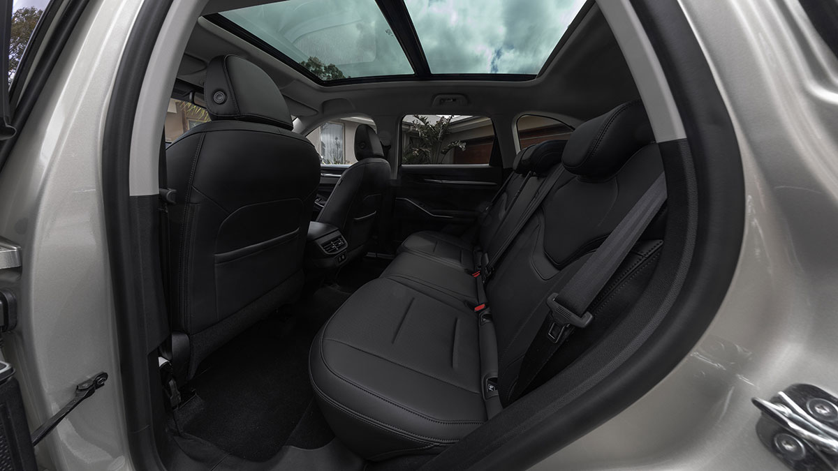 View into rear seat area of GWM Haval H6 Ultra PHEV showing dark trim, rear air vents and panoramic glass roof.