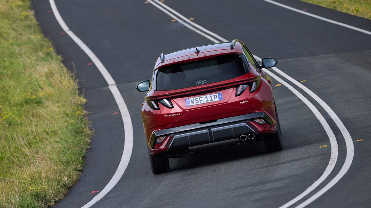red 2025 Hyundai Tucson Premium driving on road from behind