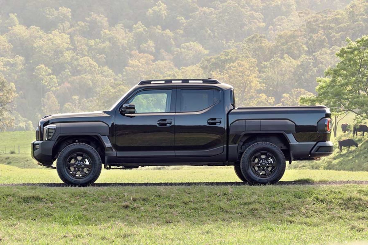 Side-on shot of Kia Tasman dual-cab ute on Australian farm