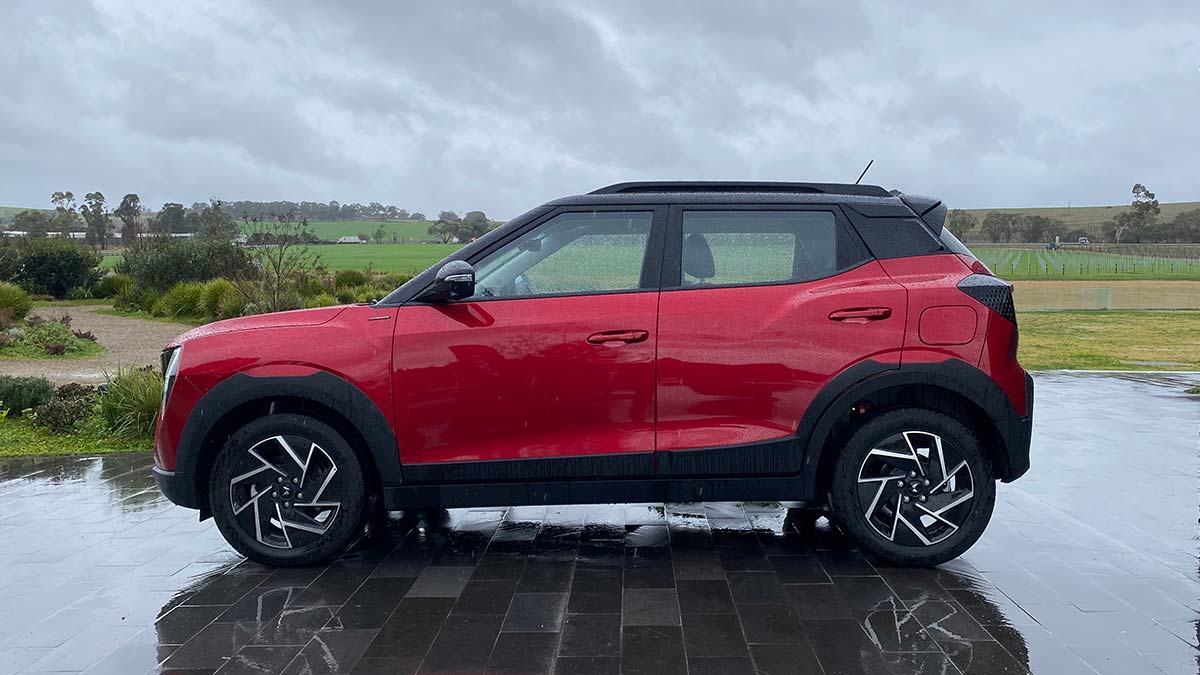 Side-on view of red Mahindra XUV 3XO small SUV in winery carpark