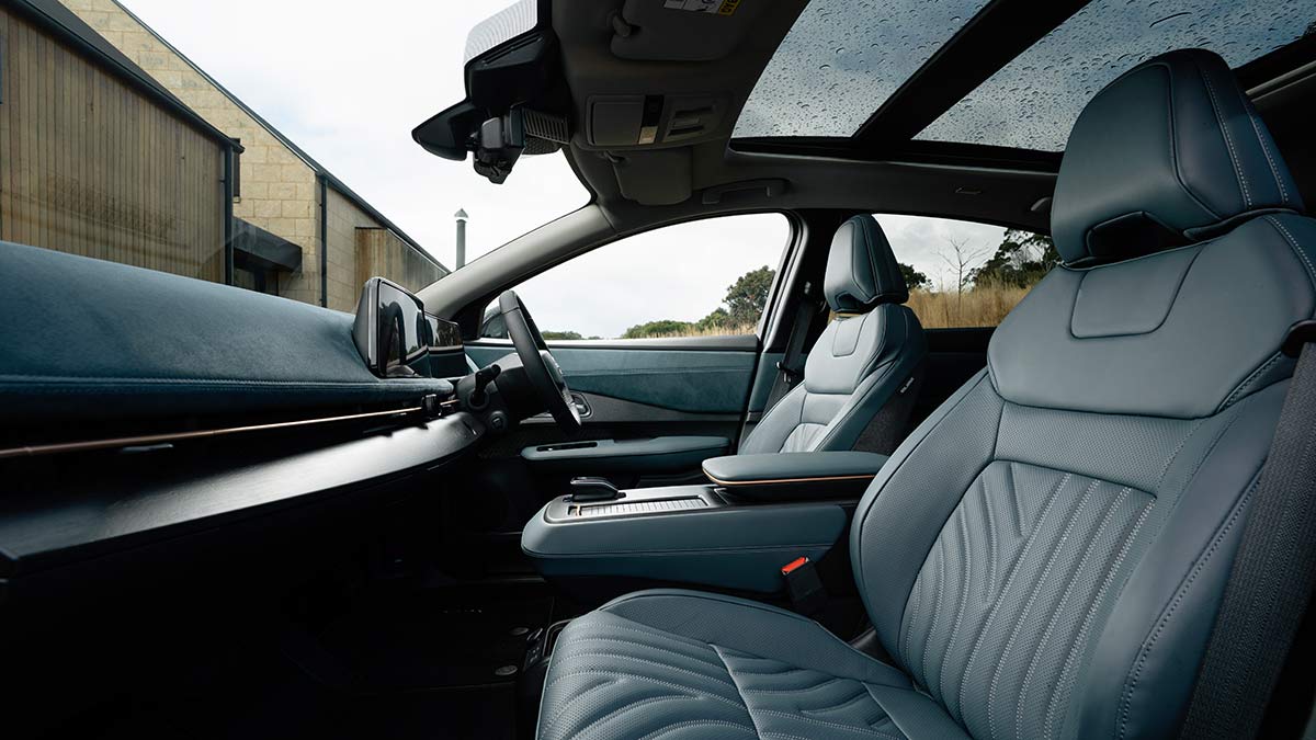 View from front passenger’s door inside Nissan Ariya Advance+ SUV showing seats and dashboard.
