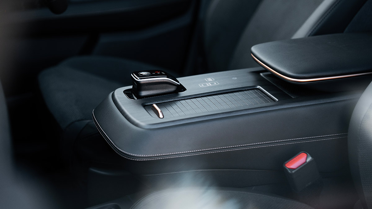 Electric-operated centre console in Nissan Ariya Advance+ SUV with drive controller and haptic buttons on top.